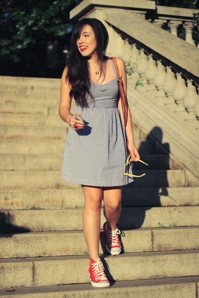 Girl wearing dress paired with red sneakers